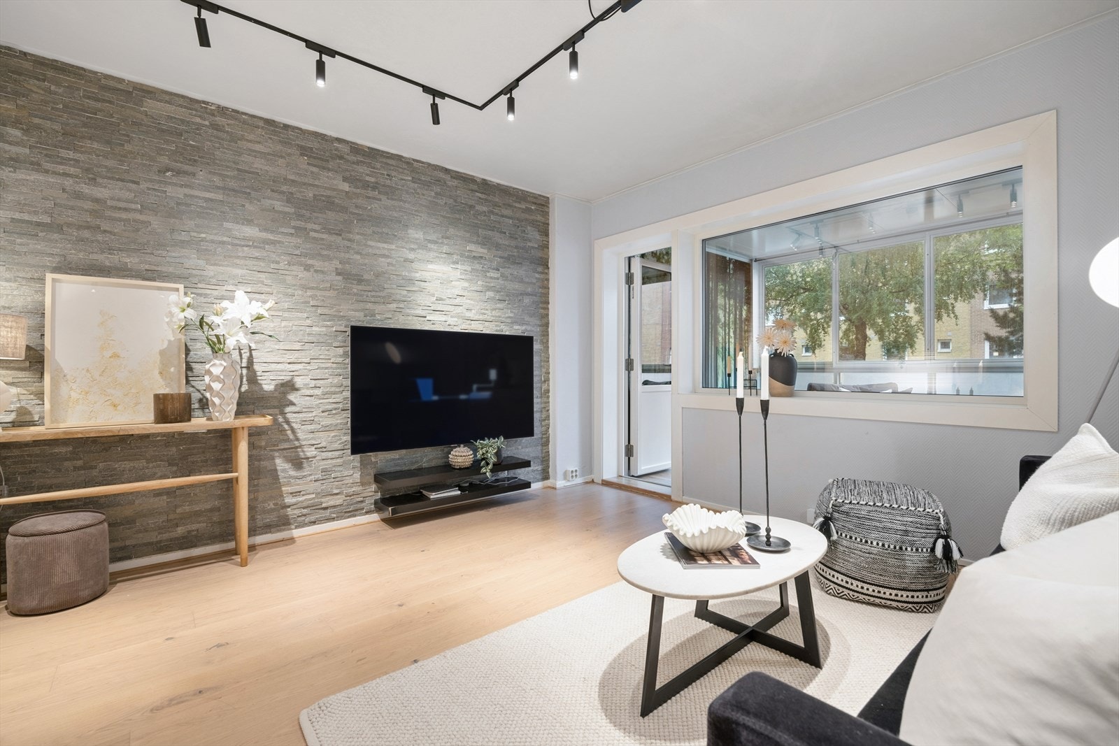 Stuen har en fondvegg i skifer og et moderne skinnesystem for belysning. Galleribilde
