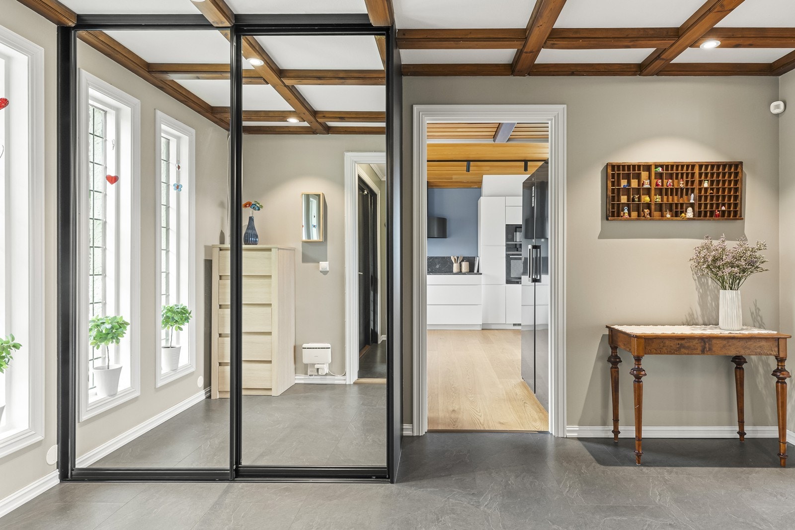 Romslig gang med stor skyvedørsgarderobe og adkomst til kjøkkenet. Galleribilde
