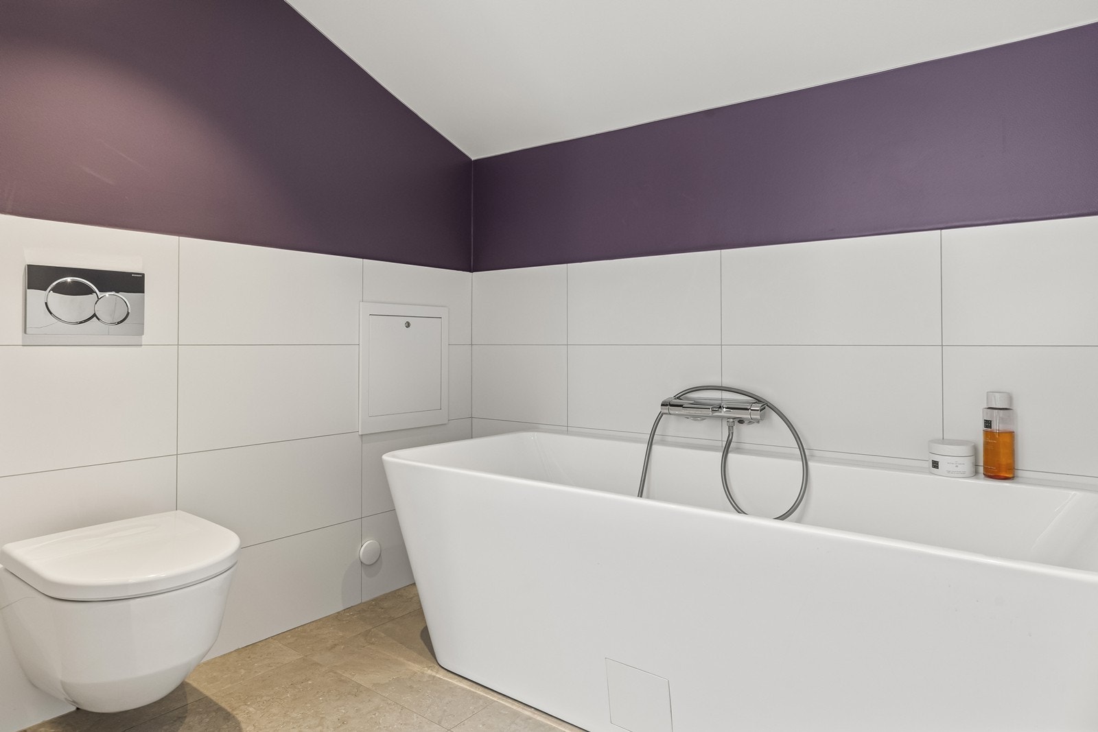 Badet er utstyrt med vegghengt toalett og et frittstående badekar. Galleribilde