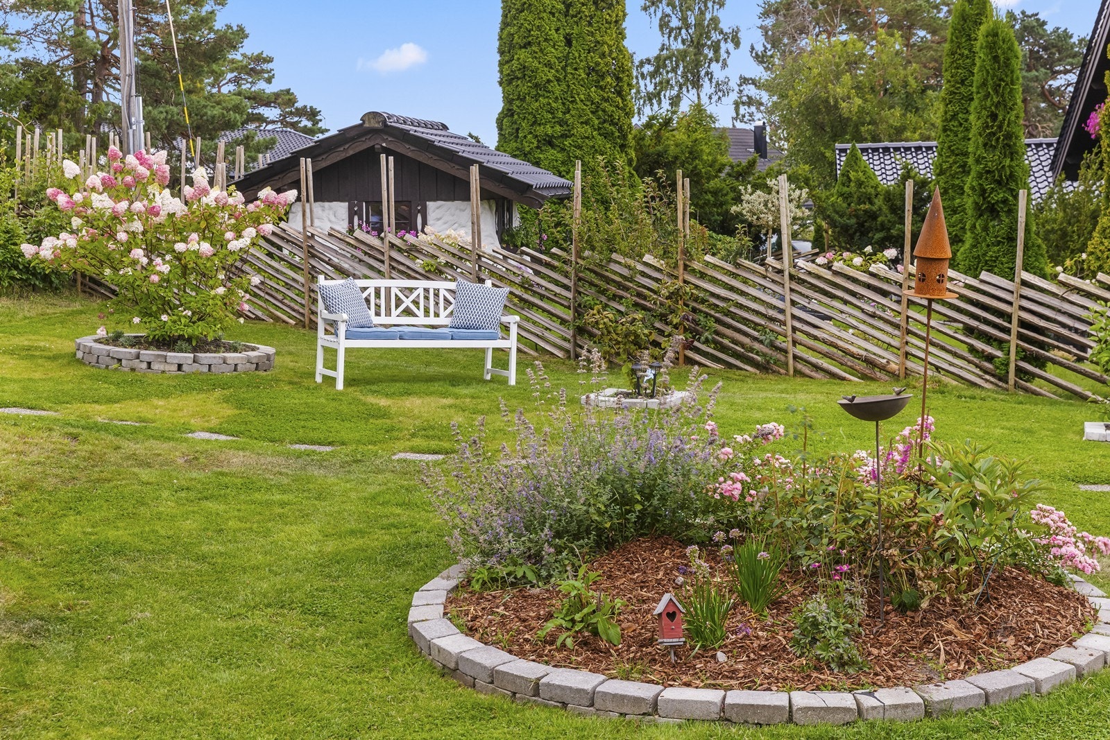 Hagen er pent opparbeidet med blomsterbed og prydbusker. Galleribilde