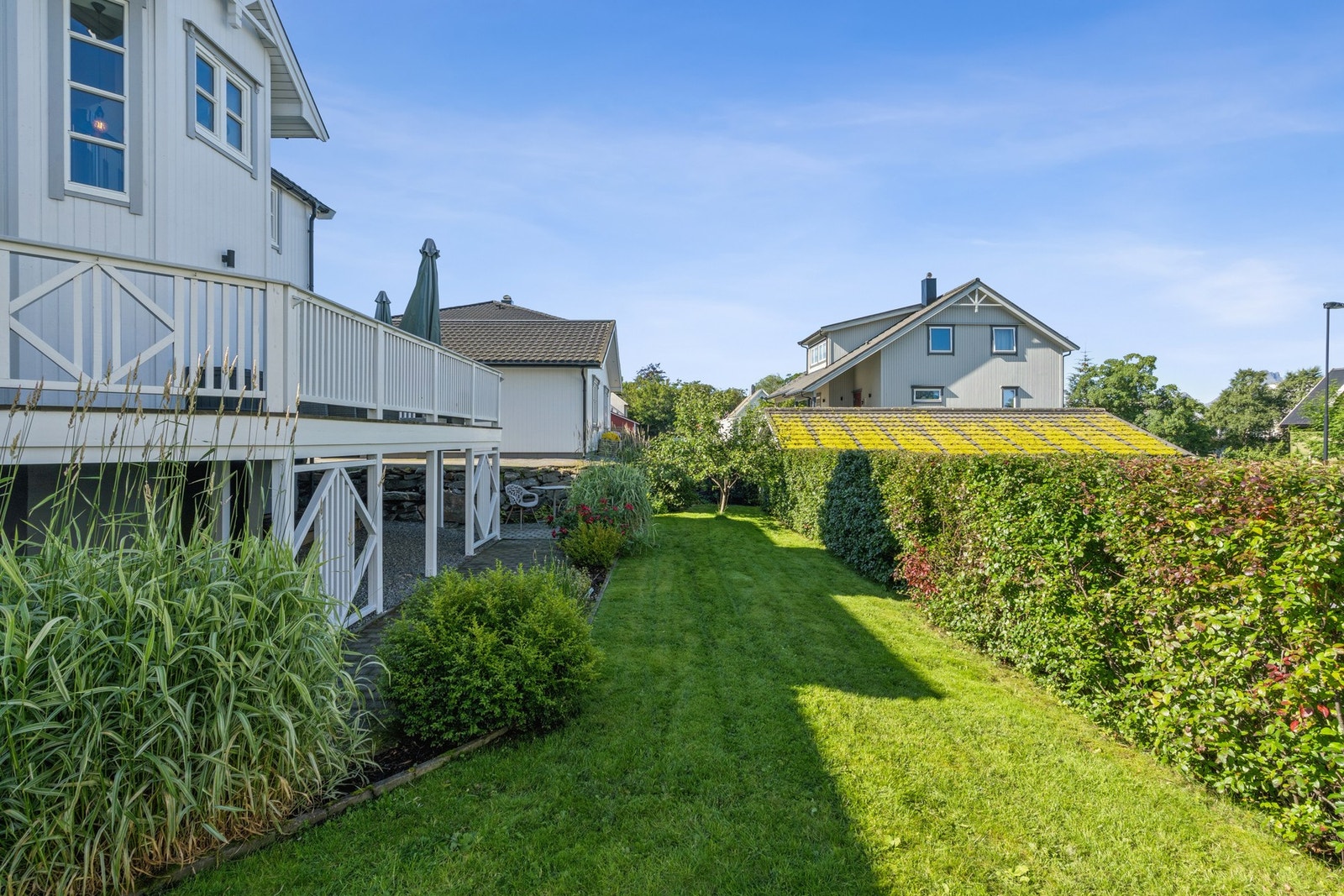 Forstøtningsmurer i naturstein og betongstein rammer inn eiendommen. Galleribilde