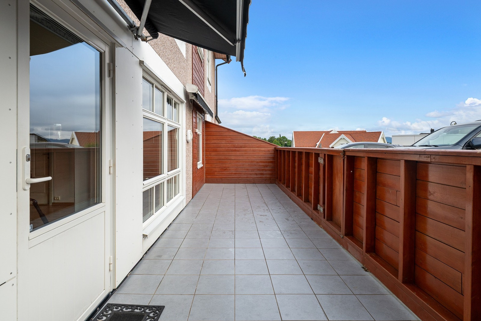 Romslig terrasse. Det er to terrassemarkiser på terrassen. Galleribilde