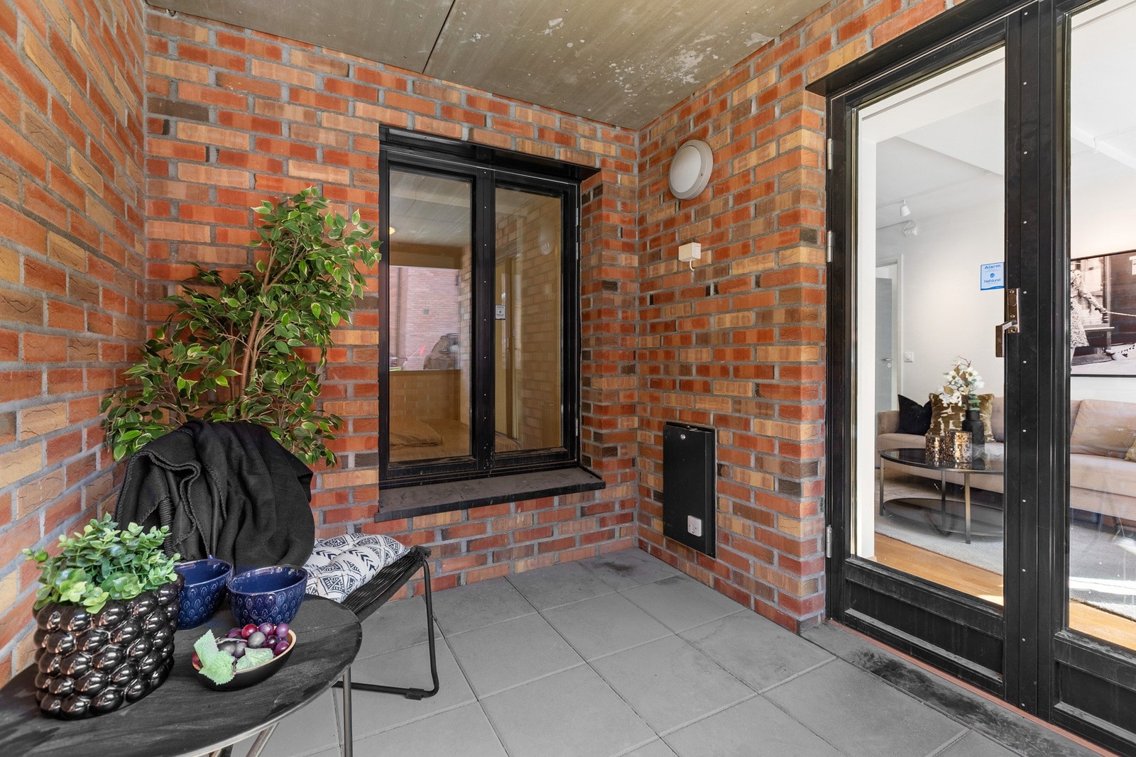 Overbygget og skjermet uteplass med teglsteinsvegger og direkte adkomst fra stuen. Galleribilde
