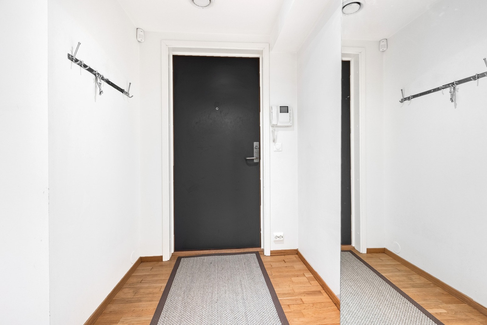 Entré med parkettgulv, lyse vegger, knaggrekke og porttelefon ved inngangsdøren. Galleribilde