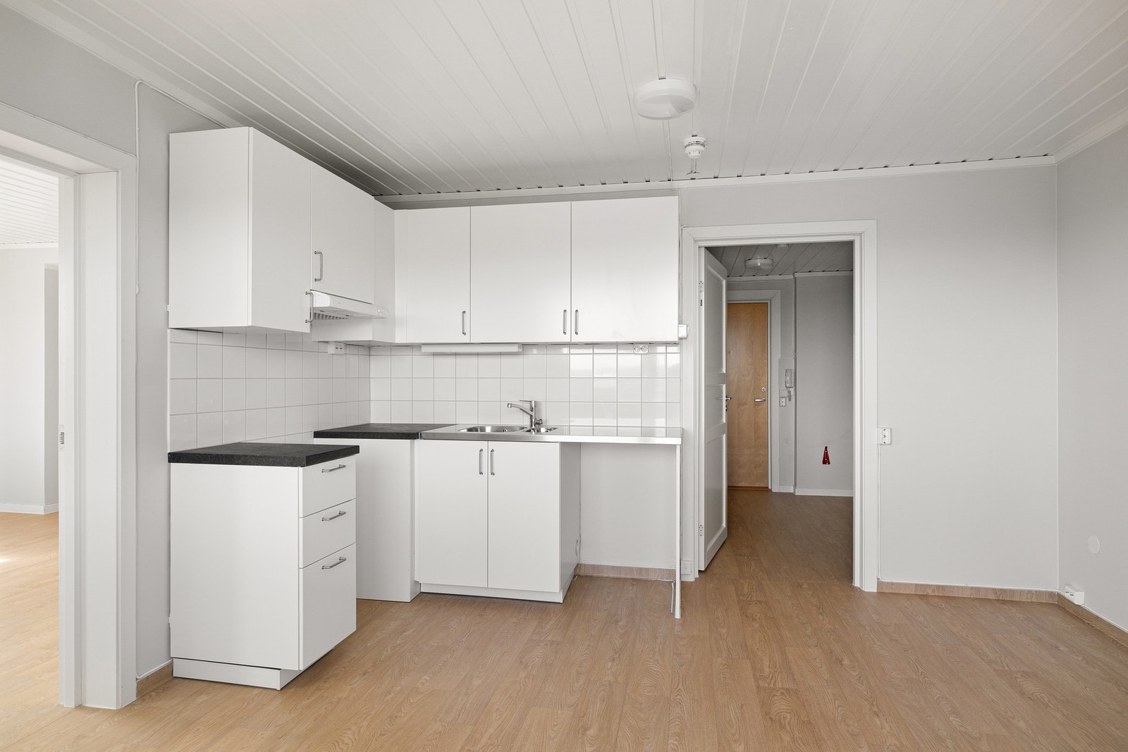 Lys kjøkkeninnredning med hvite slette fronter og laminat benkeplate. God skap- og benkeplass. Galleribilde