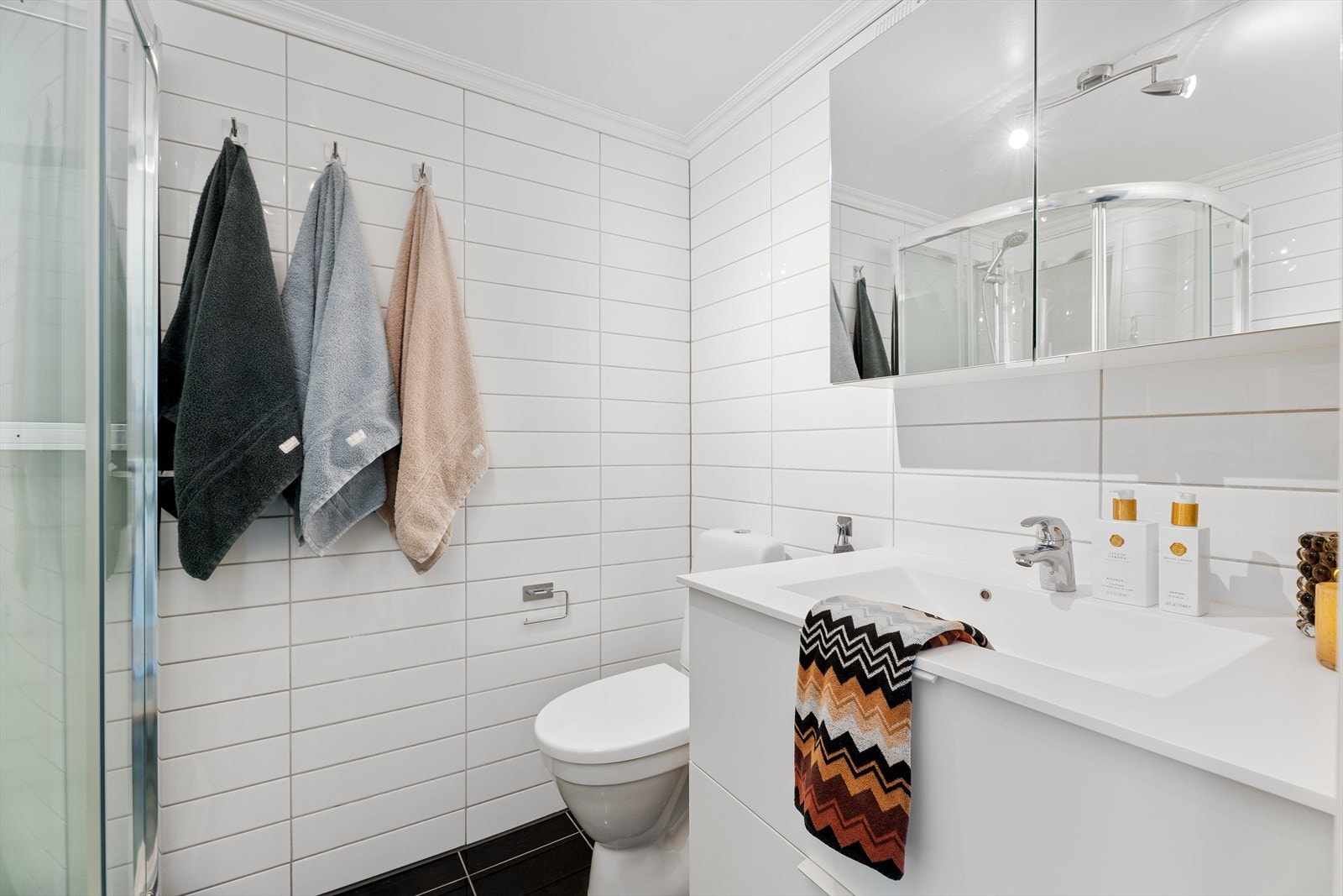 Badet fremstår lyst og funksjonelt med moderne innredning og gode oppbevaringsmuligheter Galleribilde