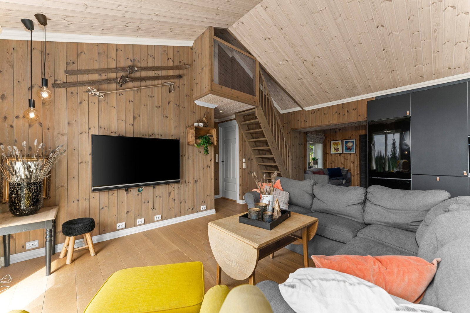 Stuen har parkett på gulvet, trepanel på veggene og en lys, skråstilt himling. Galleribilde