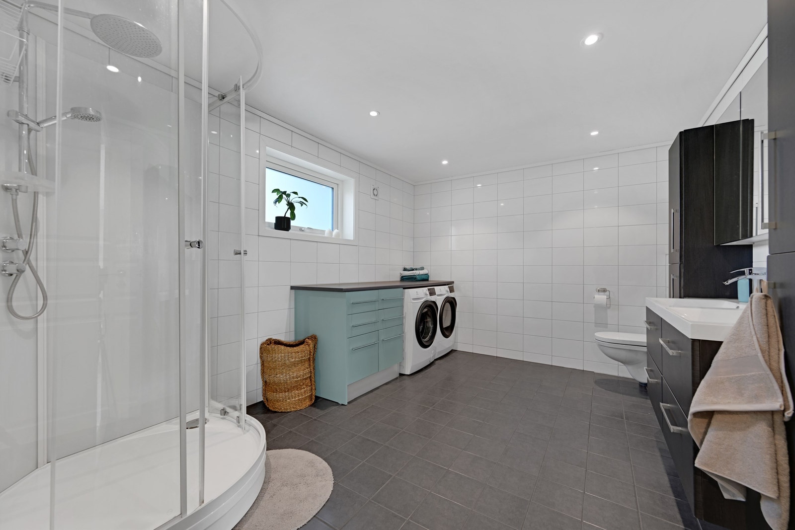 Badet har flislagt gulv med elektriske varmekabler og har plass/opplegg for vaskemaskin/tørketrommel. Galleribilde