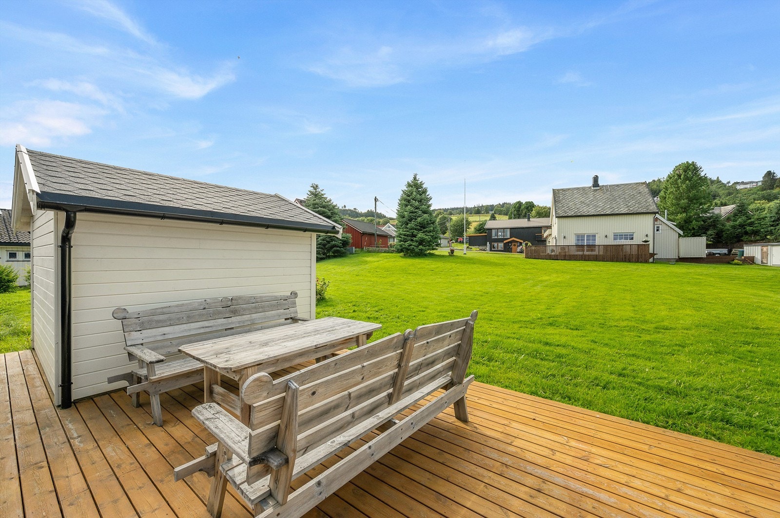 Ved garasjeområdet er det etablert en hyggelig terrasse med sittegruppe og utsyn over de store grøntarealene. Galleribilde