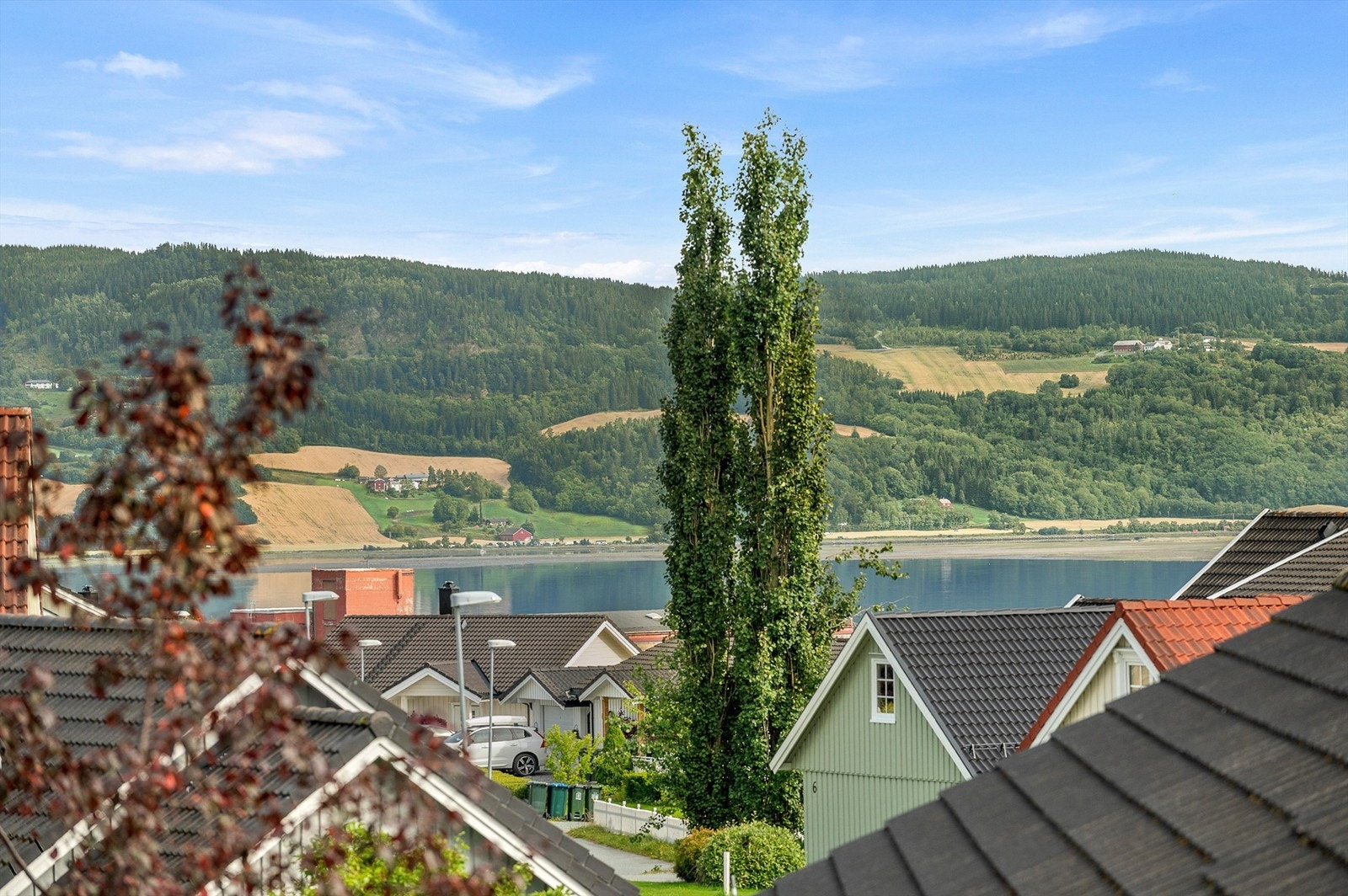 Flott utsikt i retning fjorden og det omkringliggende kulturlandskapet, med åser og grønne områder som en vakker ramme rundt nærområdet. Galleribilde