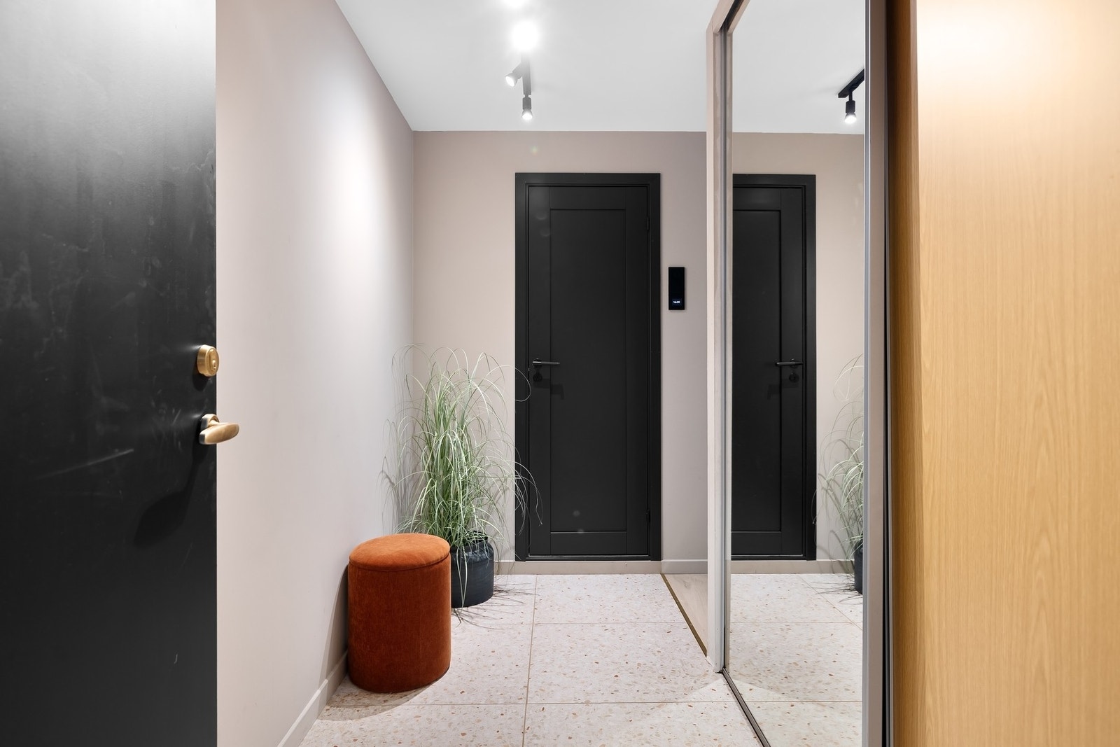 Innbydende og flislagt entre med praktisk skyvedørsgarderobe Galleribilde