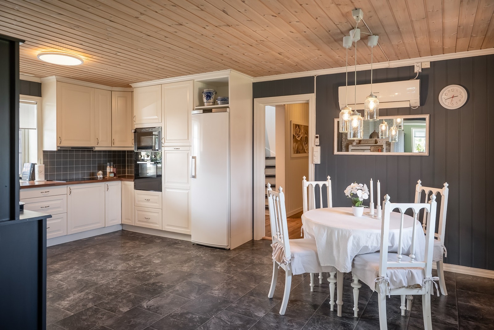 Klassisk kjøkkeninnredning i hvit utførelse, med profilerte fronter og laminert benkeplate. Galleribilde