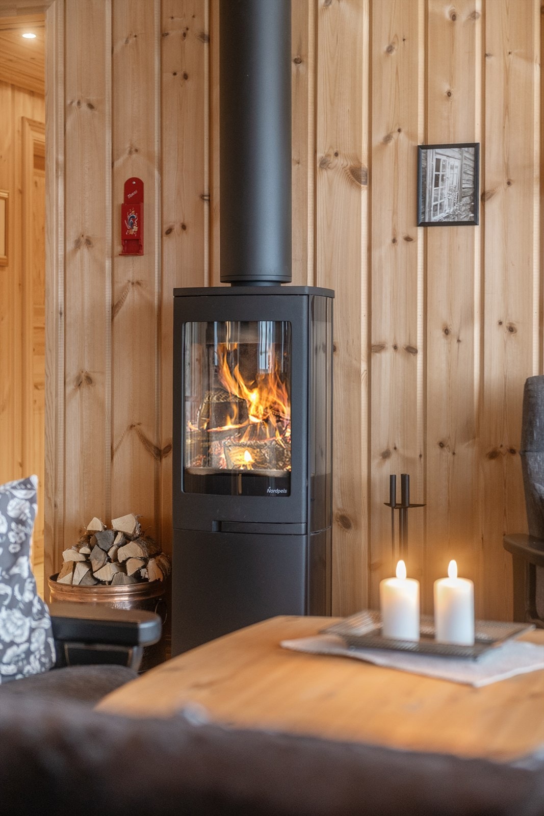 Vedovnen på stuen, tilkoblet stålpipe, sørger for effektiv oppvarming og hygge. Galleribilde