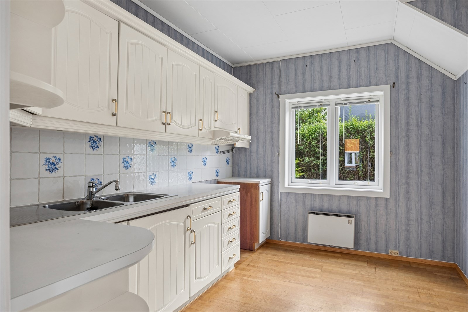 Kjøkkenet har behov for oppgradering, men her har man et kjøkkenrom på 9,5 m² og gode forutsetninger for et flott kjøkken. Vindu ut mot liten bakhage som nås via garasje. Galleribilde