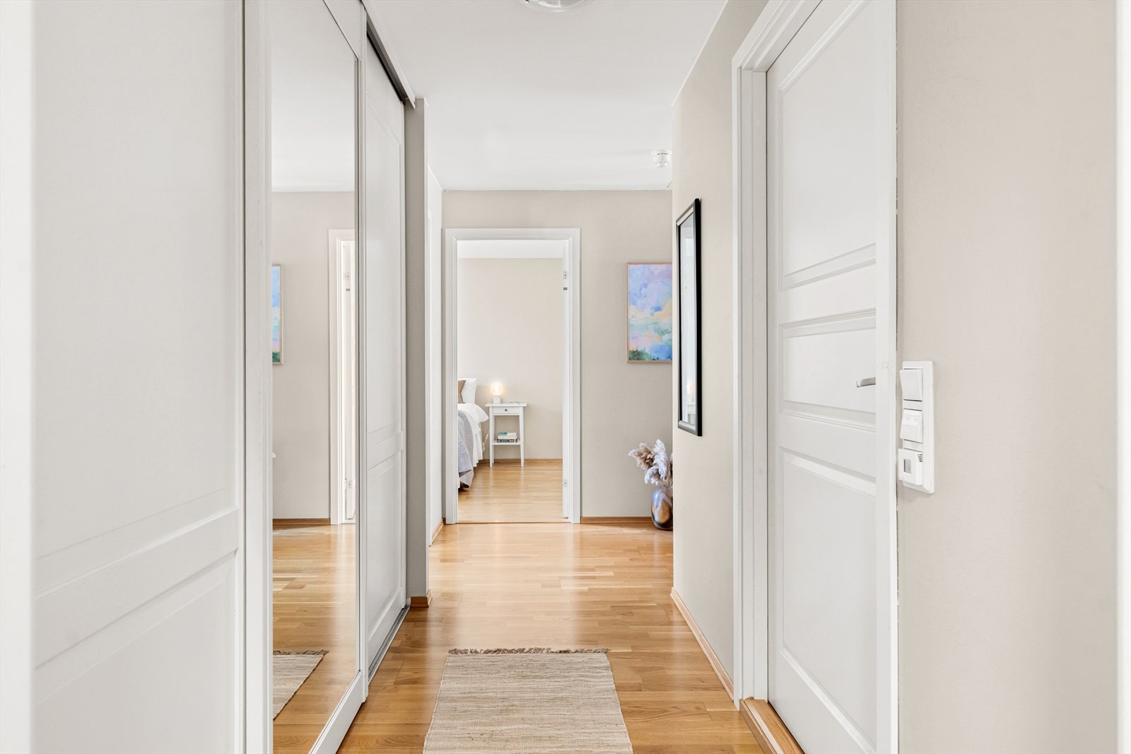 Boligen har en lys og innbydende entré, med plass til å henge fra seg yttertøy i praktisk skyvedørsgarderobe. Galleribilde