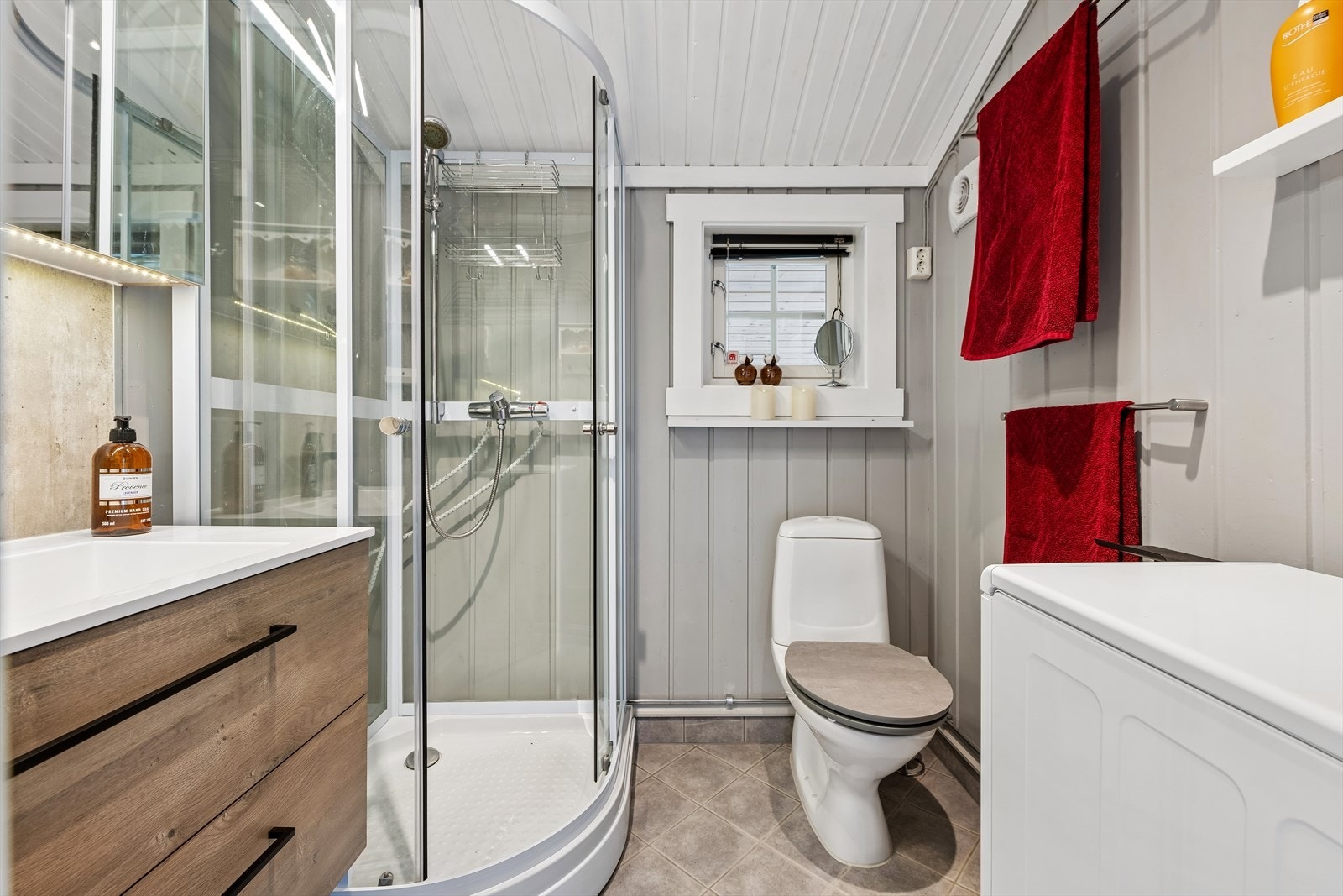 Badet har flislagt gulv med varmekabler fra 2010, dusjkabinett og servant fra 2018 samt opplegg for vaskemaskin. Galleribilde