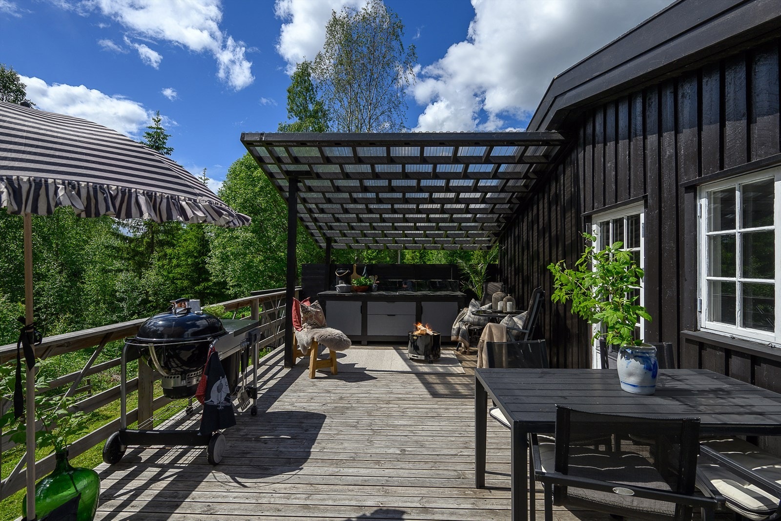 Den store, delvis overbygde terrassen er utstyrt med et praktisk utekjøkken. Galleribilde