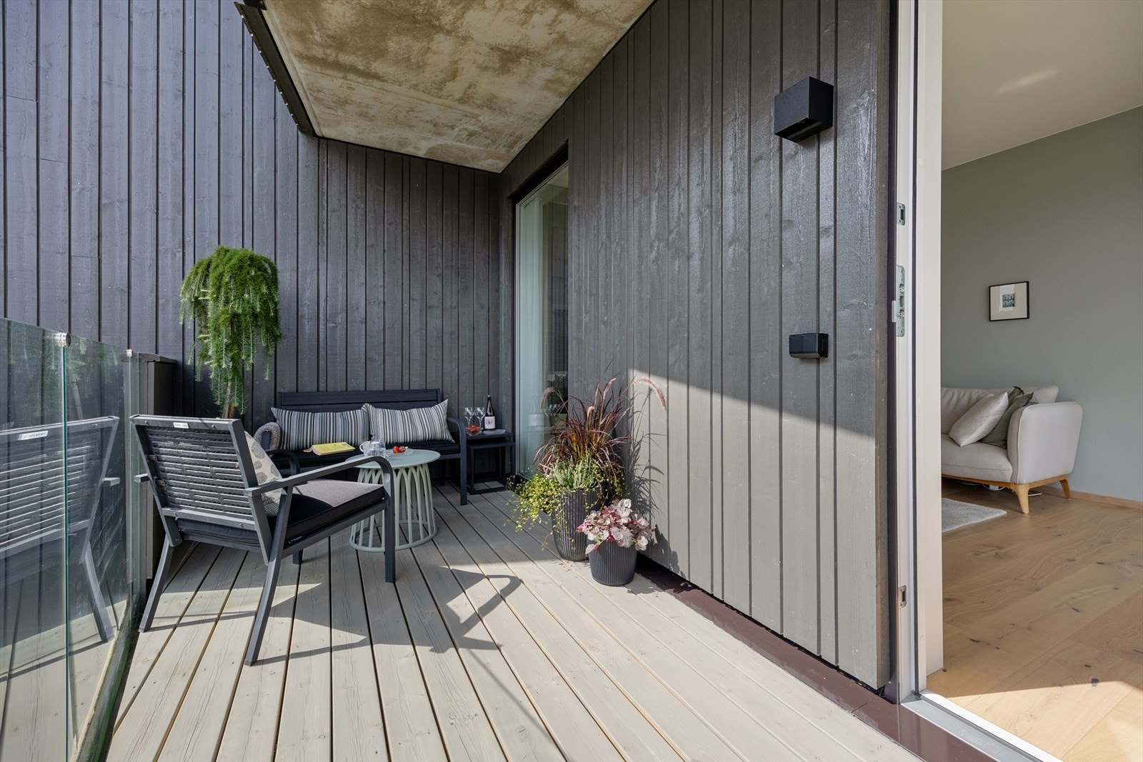 Balkongen er belagt med terrassebord, har rekkverk i glass og vender mot sør. Lun, skjermet med delvis takoverbygg. Galleribilde