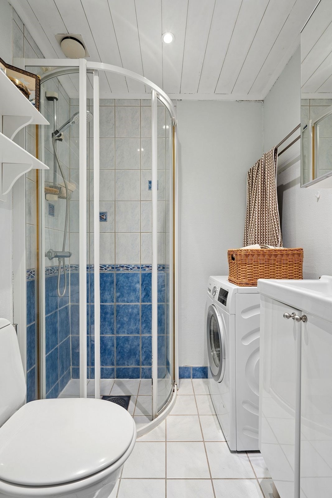 Flislagt bad med varmekabler i gulv og nedsenket himling med malte flater, samt downlights belysning i tak. Galleribilde