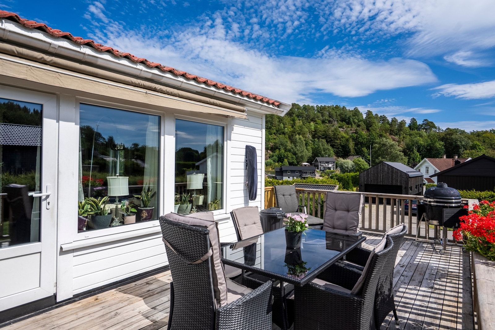 En høyt beliggende terrasse gir en flott følelse av utsyn og åpenhet, samtidig som rekkverket skaper en lun og skjermet sone som forlenger stuen utendørs Galleribilde