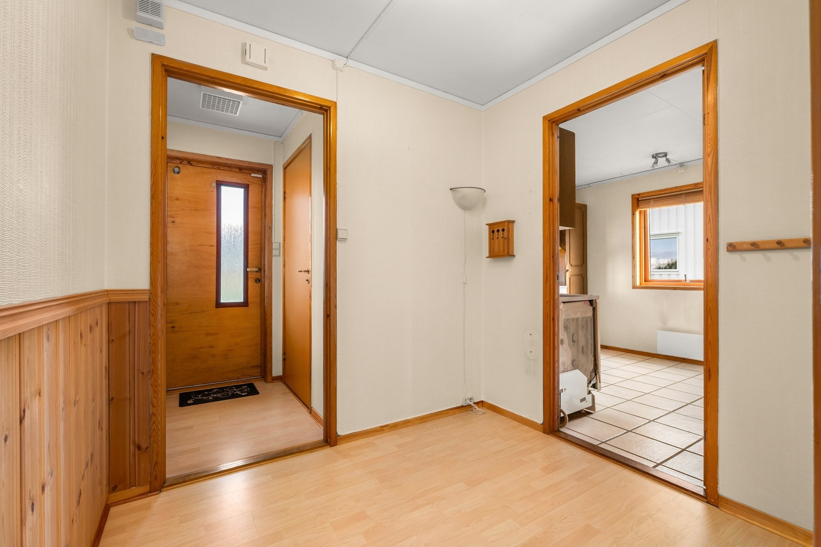 Entré med adkomst videre til boligens kjøkken og oppholdsrom. Her har man god plass til oppbevaring av yttertøy og sko. Galleribilde