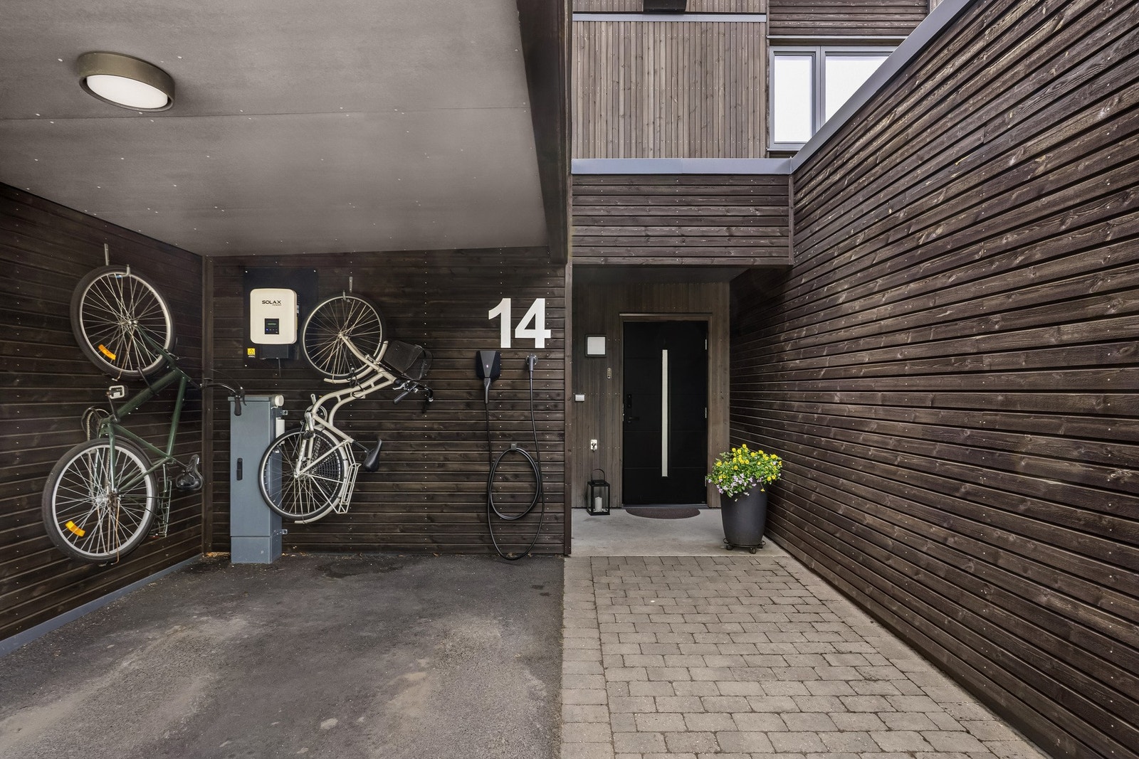 Carporten har elbillader og kroker for plassbesparende oppheng av sykler. Galleribilde