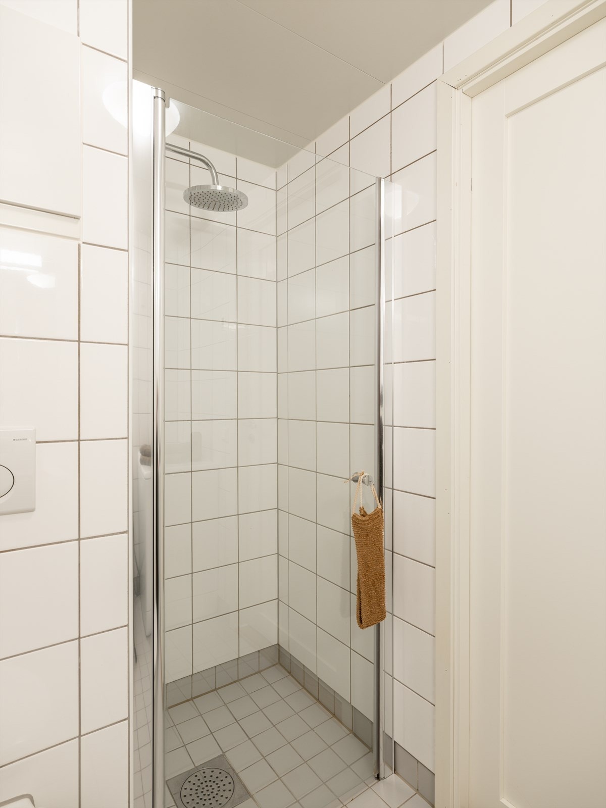 Badet er innredet med vegghengt toalett, servant nedfelt i innredning med tilhørende speil, samt dusjhjørne med svingbare glassdører. Galleribilde