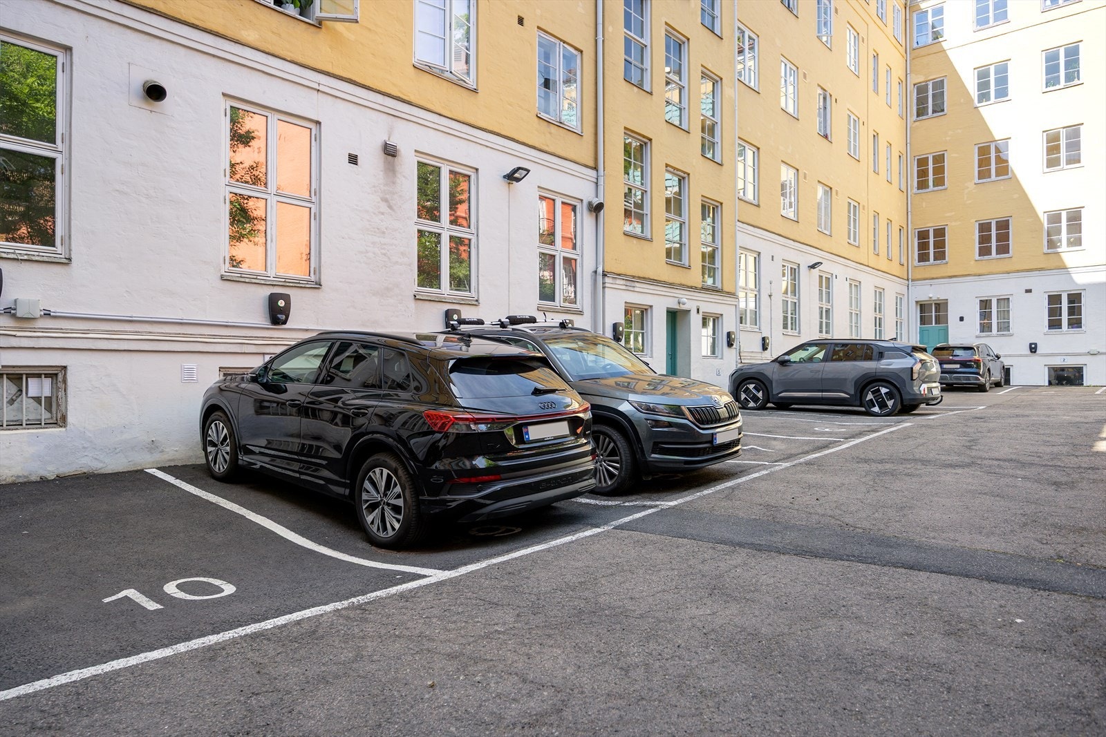 Parkeringsplasser til leie etter liste i bakgård - både langtid og korttidsparkering. Galleribilde