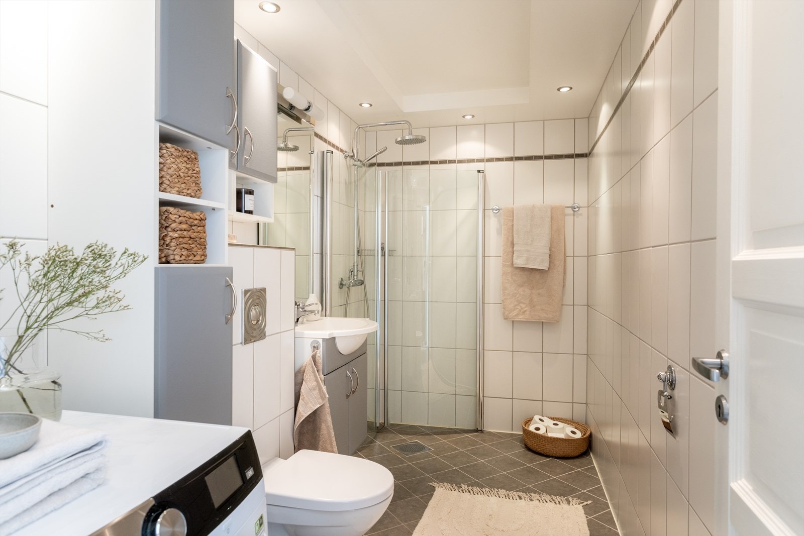 Badet er romslig og pent med lyser fliser på veggen, mens gulvet har mørkere fliser som skaper en fin kontrast. Galleribilde