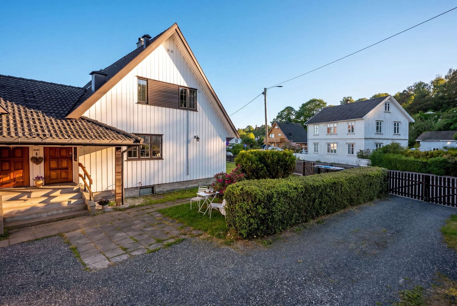 Eiendommen har adkomst via port til gruset gårdsplass med parkering i garasje og biloppstillingsplass. Galleribilde