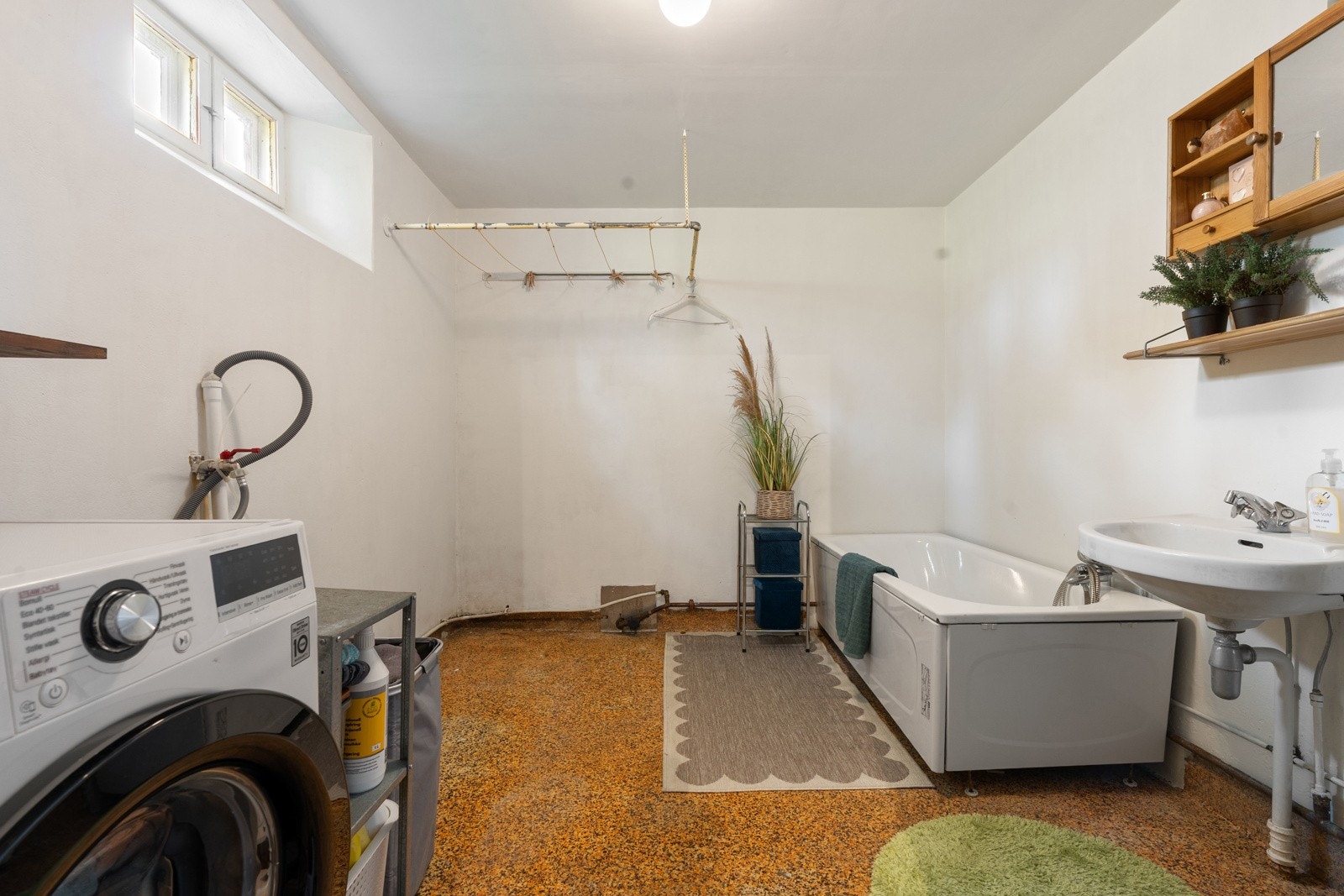 Praktisk bad som også fungerer som vaskerom, med opplegg for vaskemaskin og badekar.