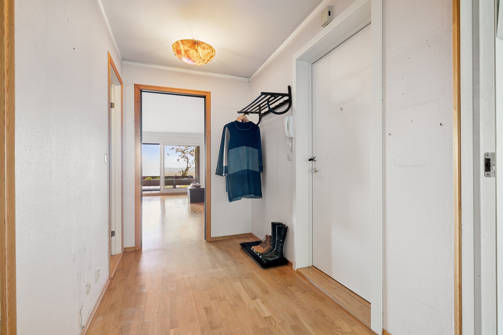 Romslig entré med parkett på gulv og porttelefon. Galleribilde