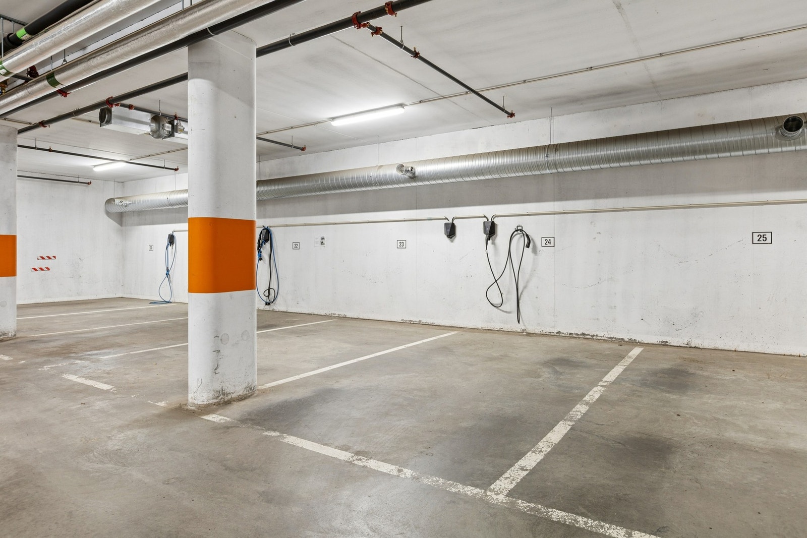 Parkeringsplass merket nr 24 med EL-billader i felles garasjeanlegg med adkomst via heis eller trapp. Galleribilde