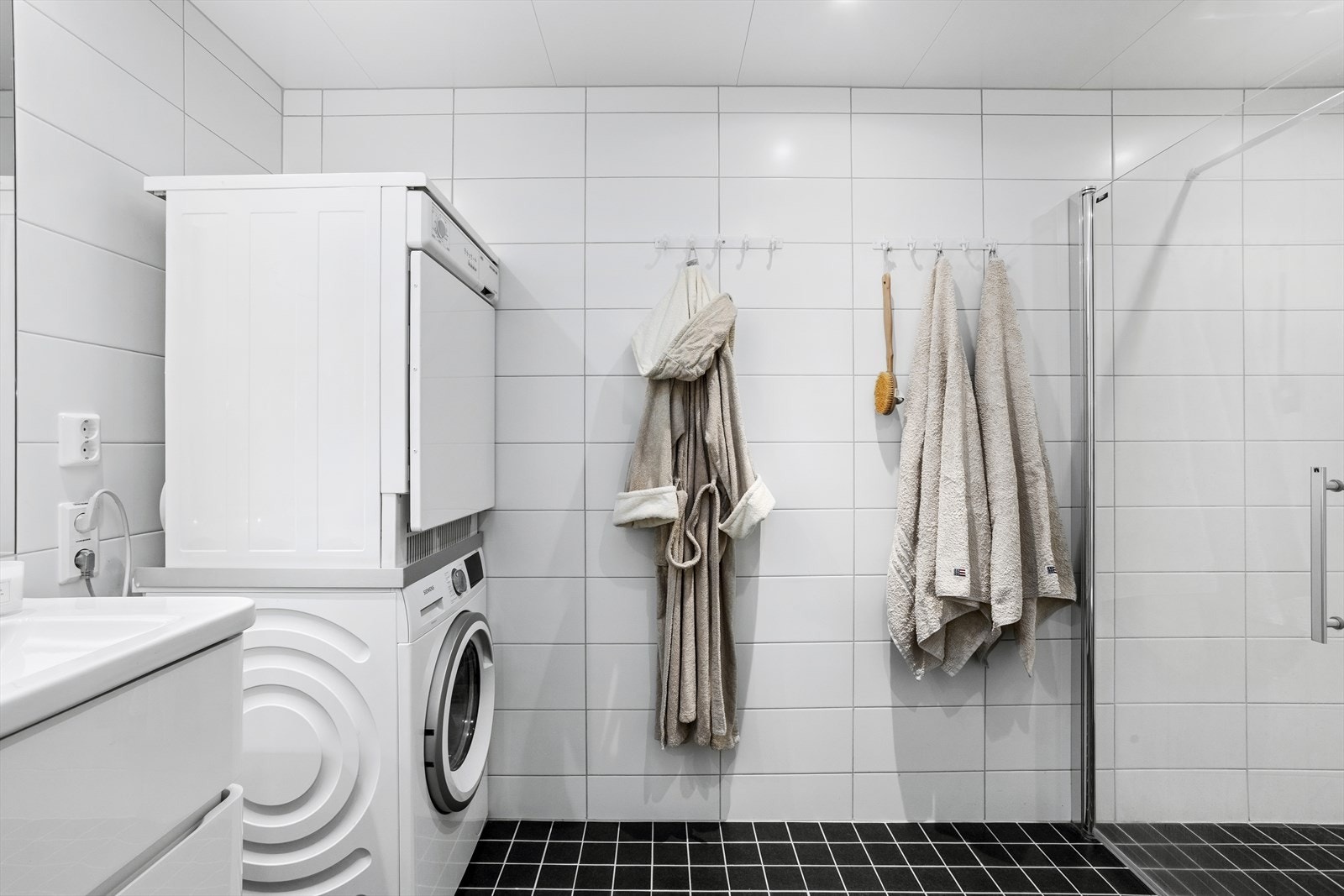Flislagt bad med varme i gulvet og opplegg for vaskemaskin. Galleribilde