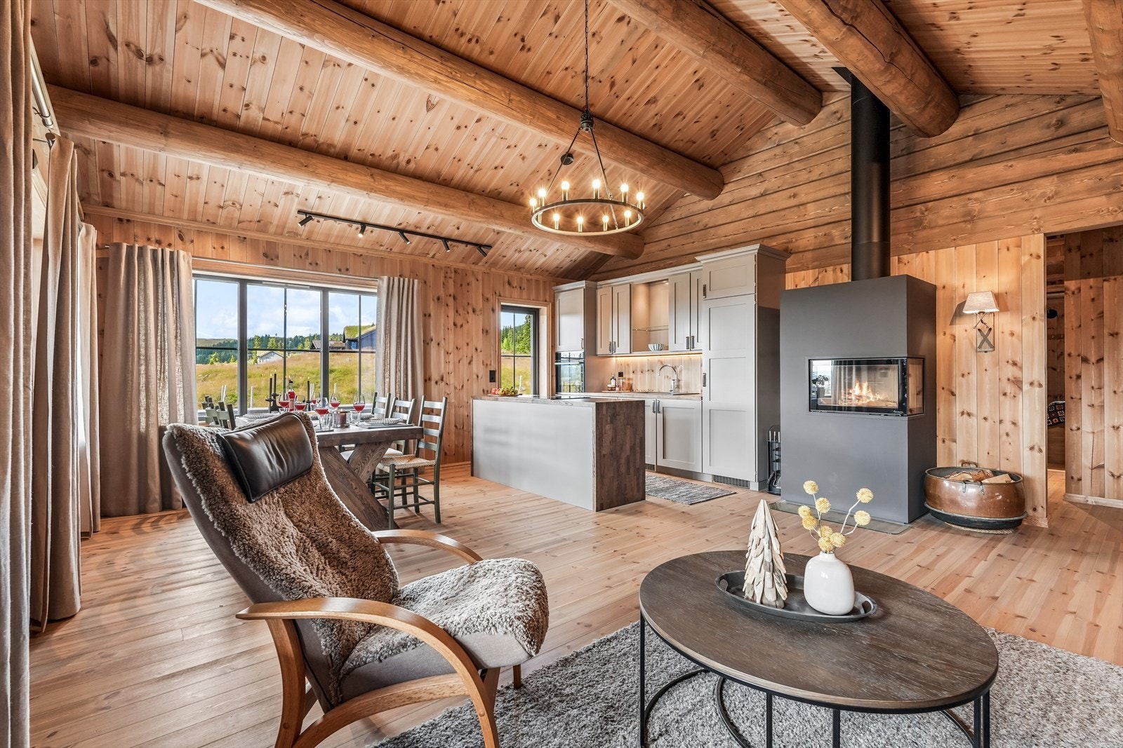 Det er god plass til både spisegruppe og sofadel, og peisen bidrar til varme og hygge gjennom hele året. Galleribilde