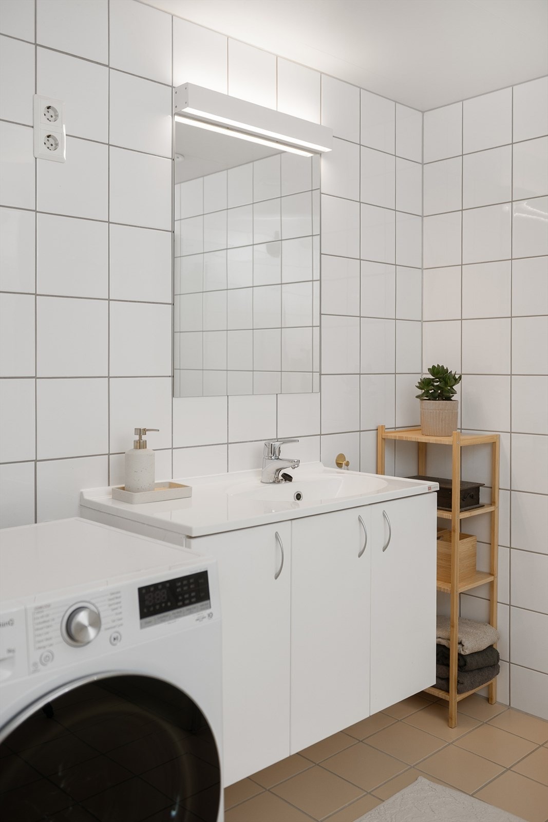 Innredning med servant, speil og belysning, samt vegghengt toalett. Galleribilde