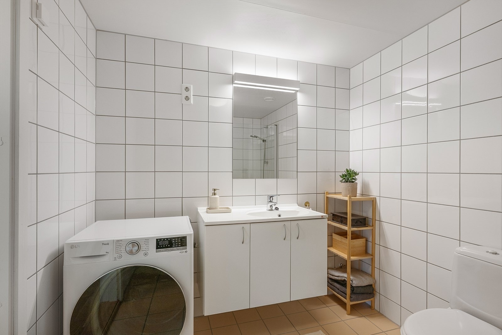 Badet har opplegg for vaskemaskin og god plass til oppbevaring. Galleribilde