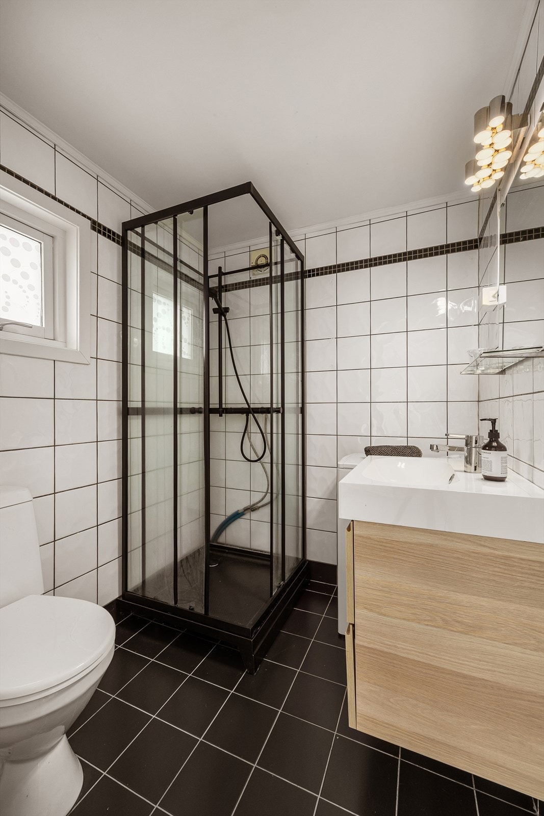 Badet er utstyrt med dusjkabinett og servantinnredning. Galleribilde