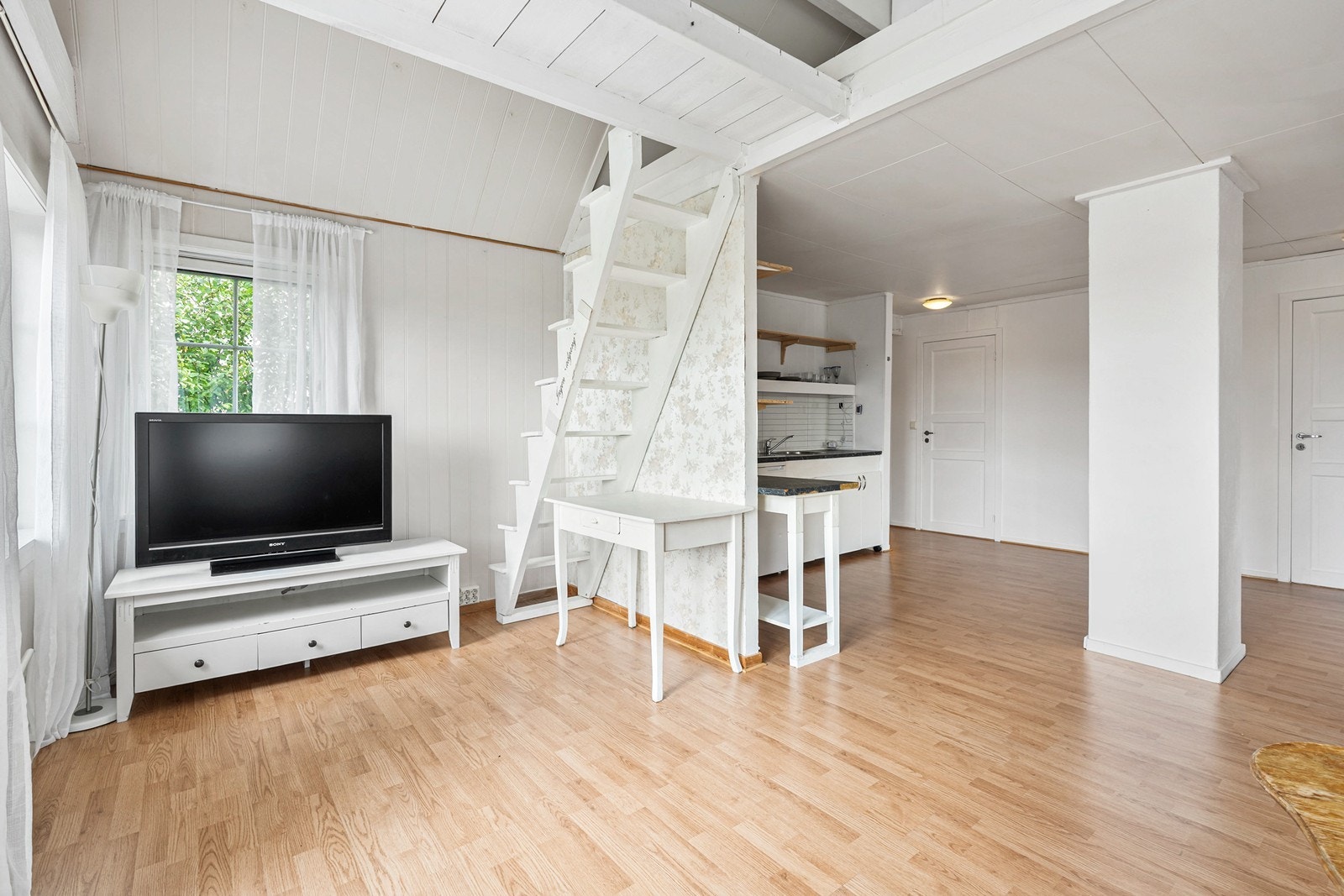 I stuen er det høyt i taket og det er bygget en enkel hems. Galleribilde