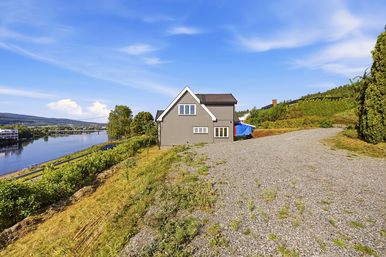 Huset ligger innerst i blindveien med romslig, gruset parkeringsplass ved siden av. Galleribilde