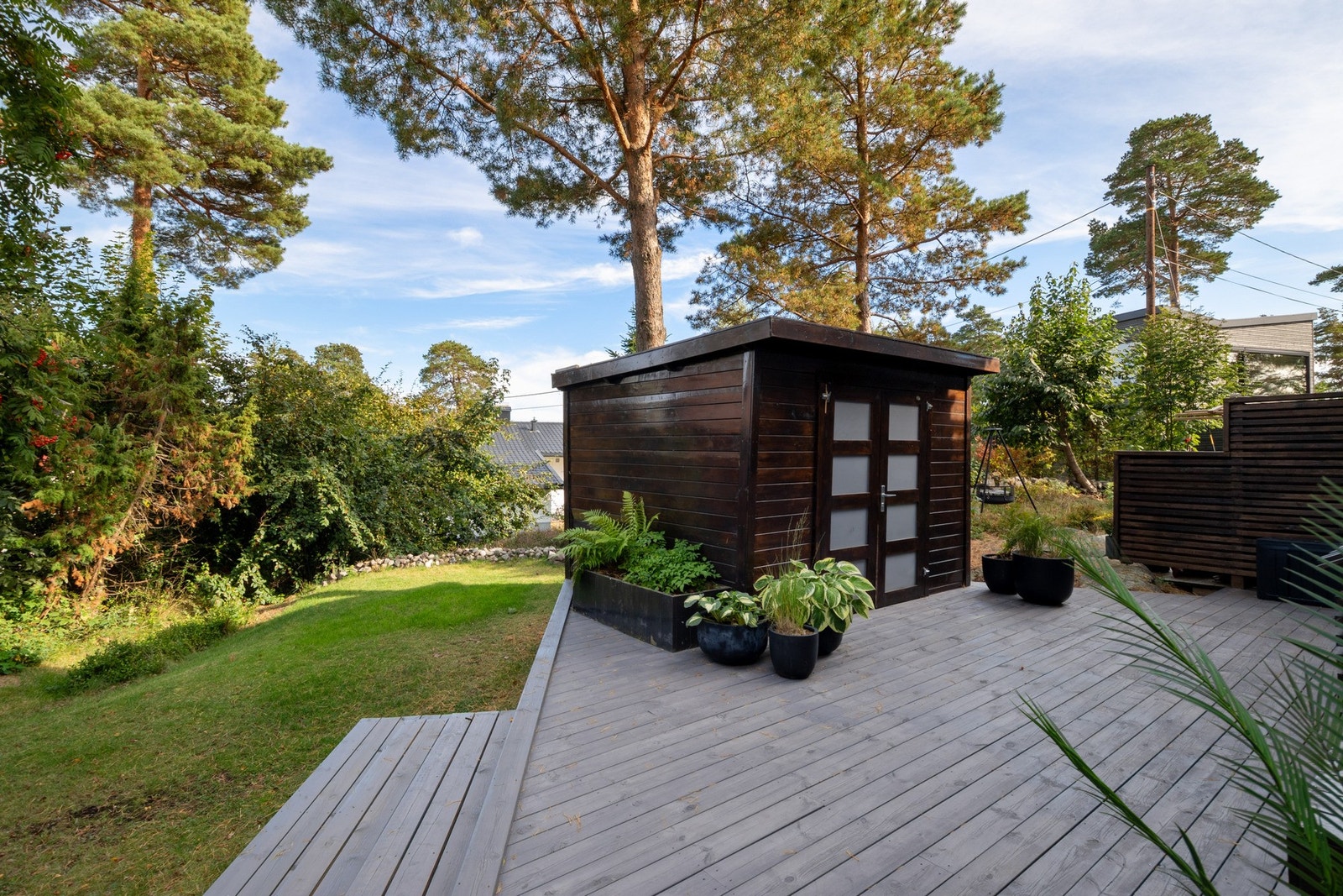 Terrasseplattingen på terreng er på 24 kvm, med enkel utebod ved siden av. Galleribilde