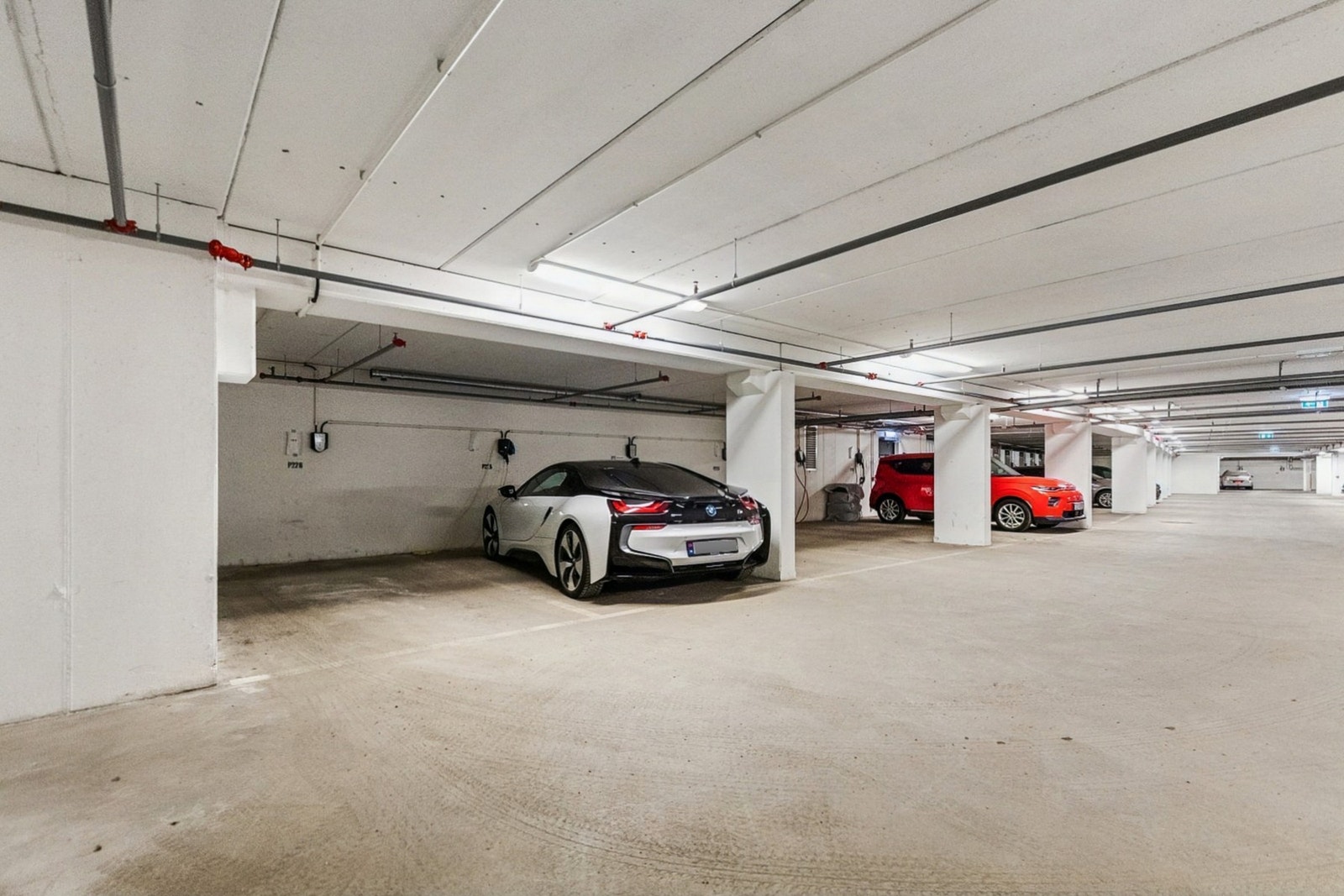Parkeringsplass i felles parkeringskjeller med elbil-lader. Galleribilde