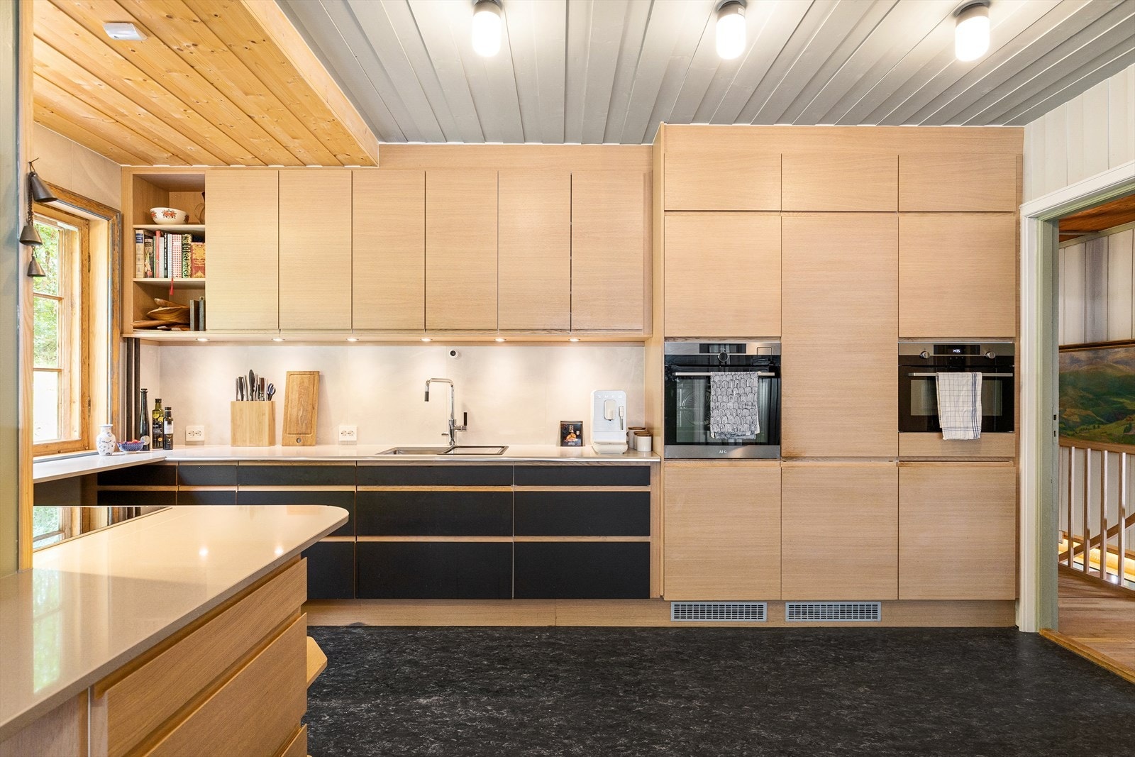 Den koksgrå linoleumen spiller sammen med skuffefrontene og Silestone-benkeplatene med nedfelt stålkum. Galleribilde