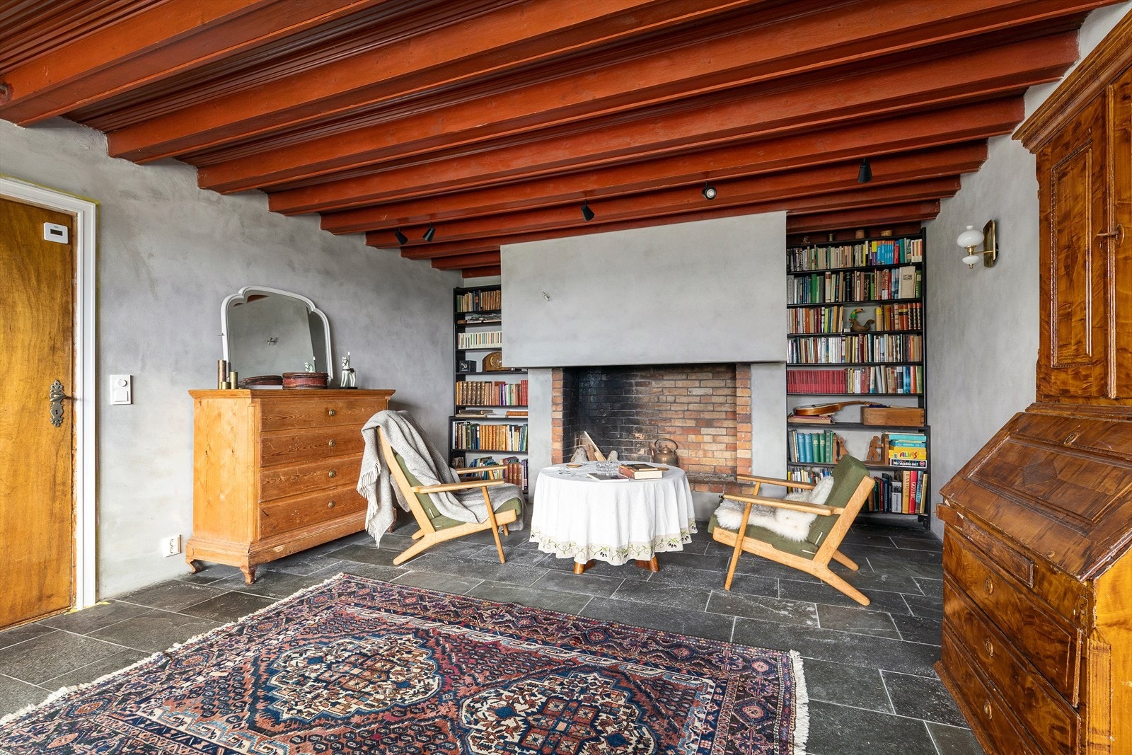 Klassisk peisestue fra 1930-årene med bjelker i taket og stor, arkitekttegnet peis fra 1937. Galleribilde