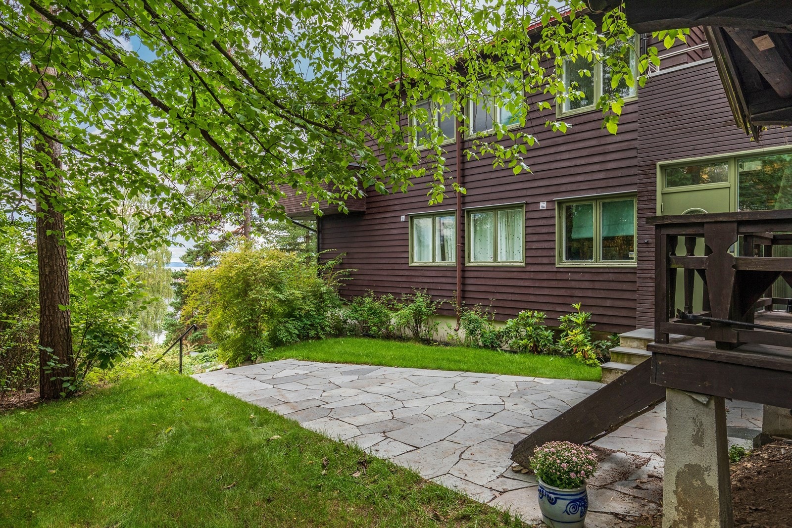 Frodig Inngangsparti til 2. etg på østveggen med hyggelig og usjenert uteplass. Huset er miljøvennlig malt med linoljemaling og isolert med Hunton trefiber. Galleribilde