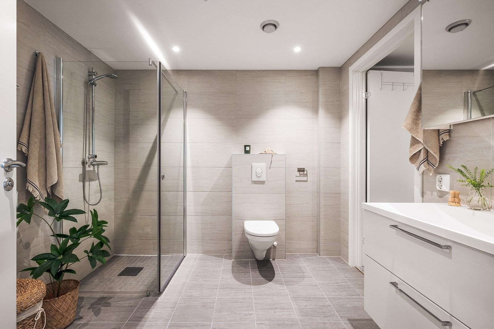 Moderne helfliset bad med varme i gulv og innfelte spotlights i tak. Galleribilde