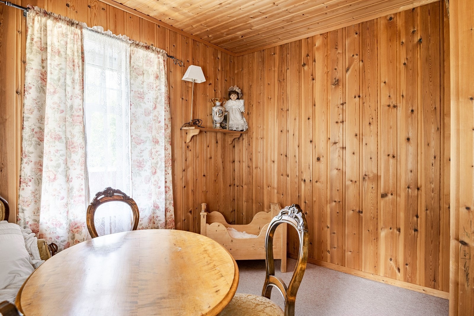 Rommet har lunt teppegulv, panel på veggene og vinduer mot to ulike himmelretninger. Galleribilde