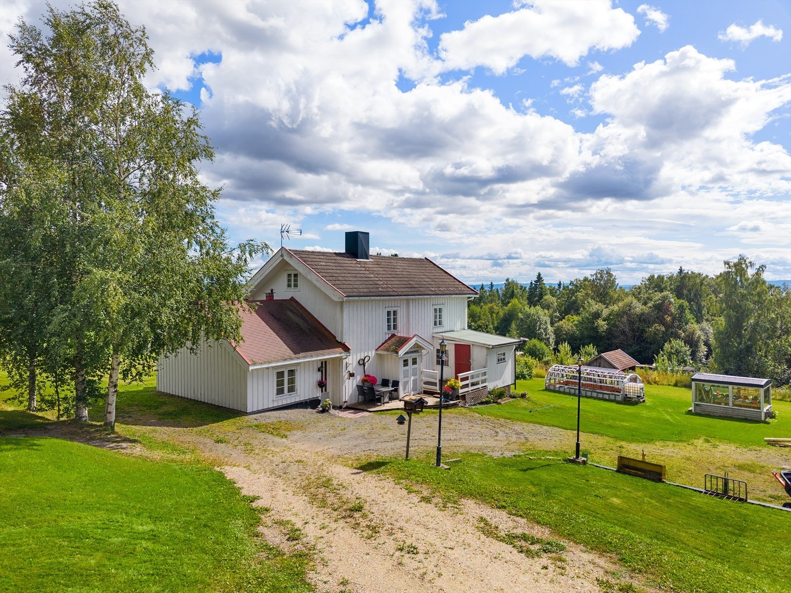 Eiendommen har et hyggelig tun med blant annet drivhus og andre småbygninger. Galleribilde