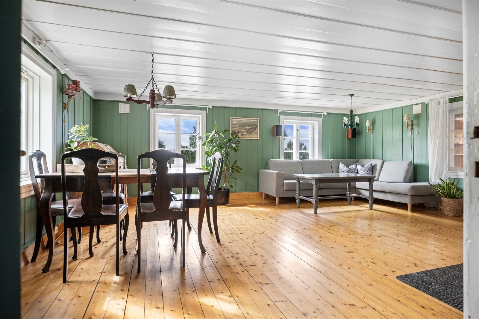 Her får du en stor og hyggelig stue med tregulv og malt panel på vegger og i himlingen. Galleribilde