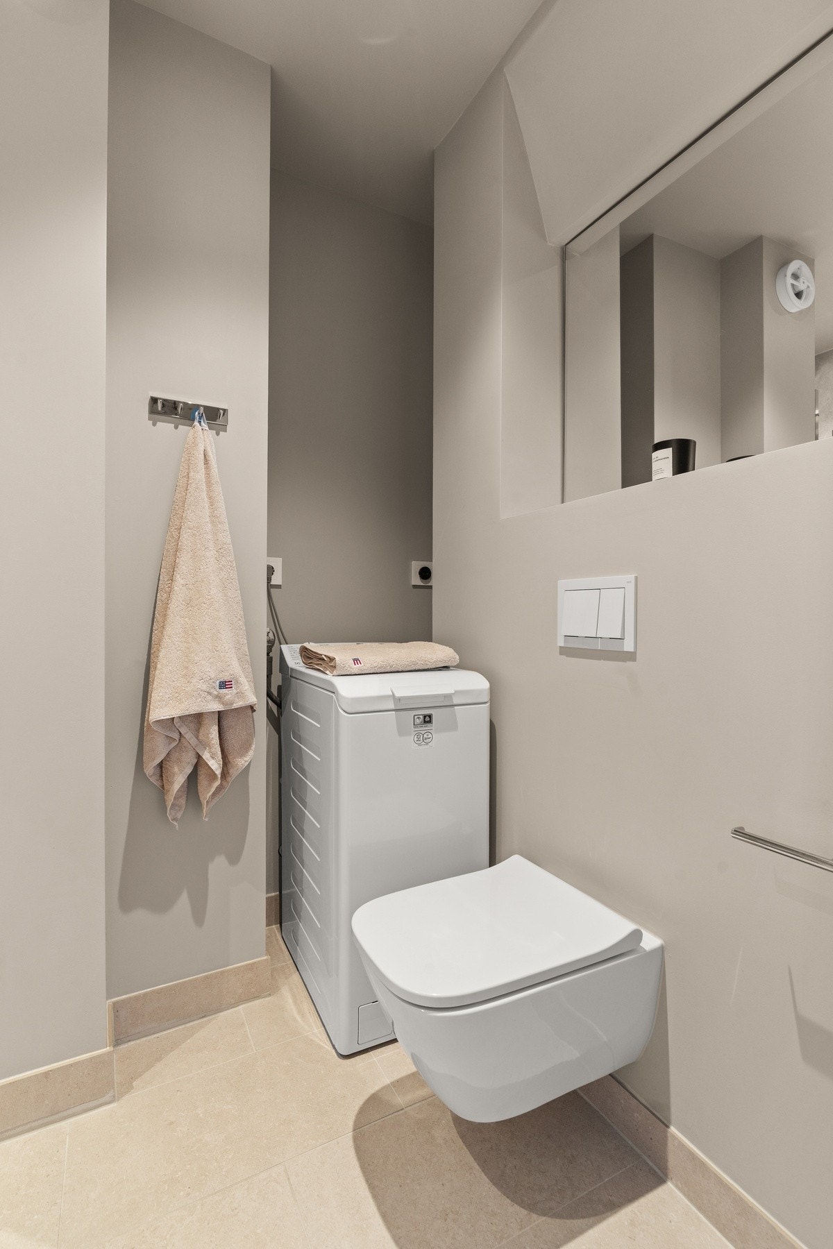 Videre er badet utstyrt med vegghengt toalett og opplegg for vaskemaskin. Galleribilde